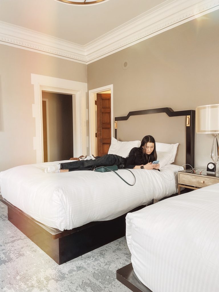 Girl sitting on bed at Fairmont Empress